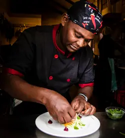 head chef Stephen Musyoka plating a dish at the emakoko